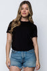 Woman wearing a black t-shirt and denim shorts against a white background