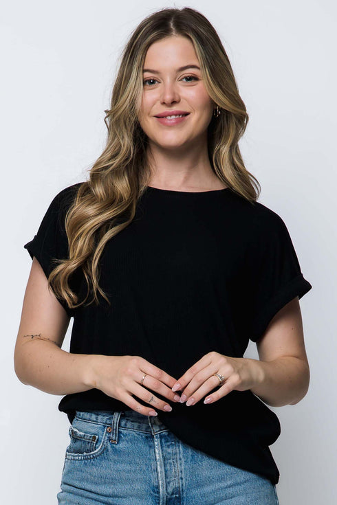 Woman wearing a black t-shirt and blue jeans against a white background
