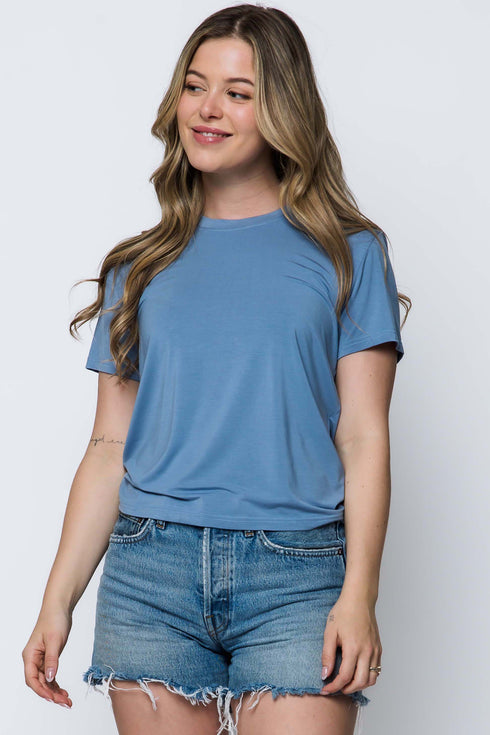 Woman wearing a blue t-shirt and denim shorts on a white background