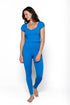 A woman modeling a bright blue two-piece loungewear set consisting of a short-sleeve scoop-neck top and matching high-waisted leggings, shot against a plain white studio background.