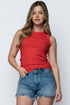 Woman wearing a red tank top and denim shorts against a white background