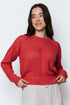 Woman wearing a red knitted sweater against a white background