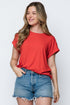 Woman wearing a red t-shirt and denim shorts on a white background