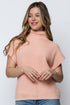 Woman wearing a light pink sweater against a white background