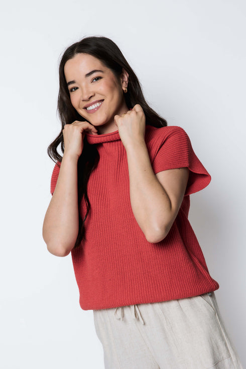 Woman wearing a red sweater against a white background
