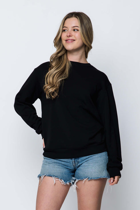 Woman wearing a long sleeve, crew neck luxe fleece black sweatshirt