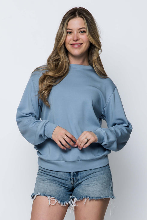 Woman wearing a long sleeve crew neck blue sweatshirt