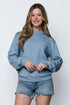 Woman wearing a long sleeve crew neck blue sweatshirt