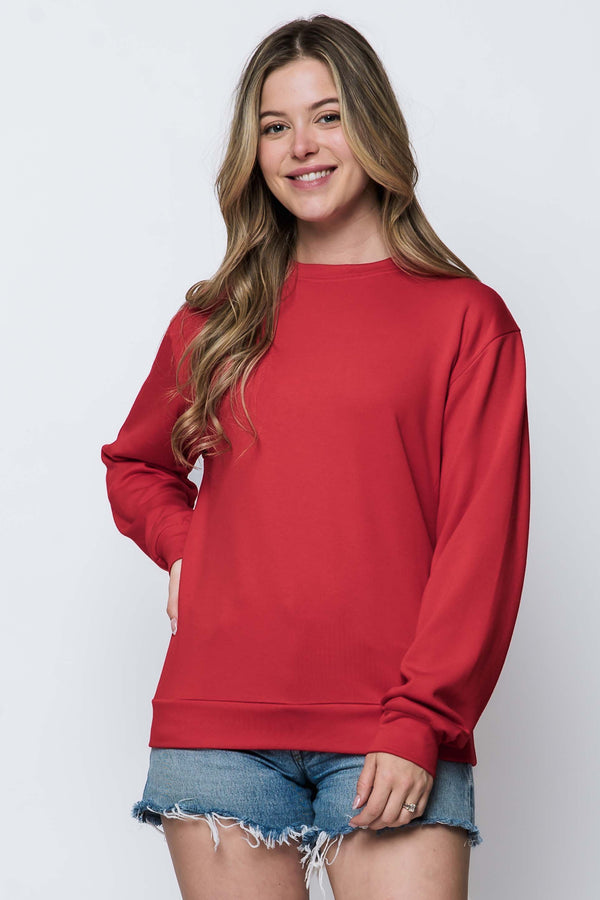 Woman wearing a red sweatshirt and denim shorts on a white background