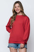 Woman wearing a red sweatshirt and denim shorts on a white background