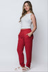 Woman wearing a white top and red luxe fleece cuffed sweatpants