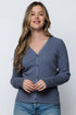 Woman wearing a blue cardigan against a white background