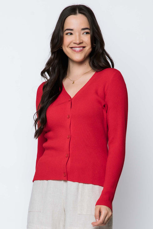Woman wearing a red cardigan over a white top on a white background