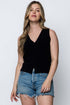 Woman wearing a black sleeveless top and denim shorts on a white background