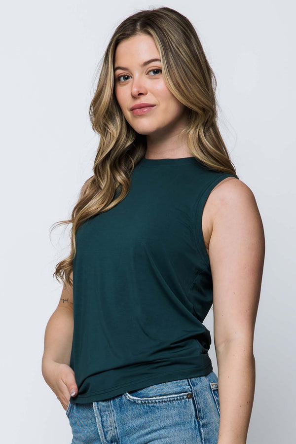 Woman wearing a green sleeveless top on a white background