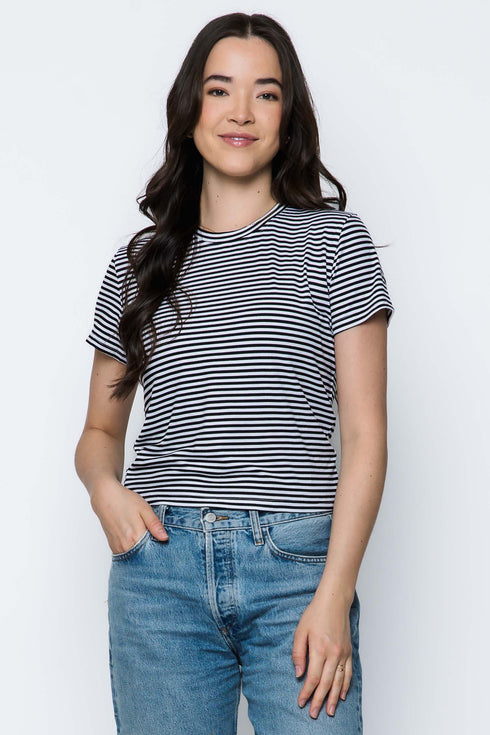 Woman wearing a striped t-shirt and jeans against a white background