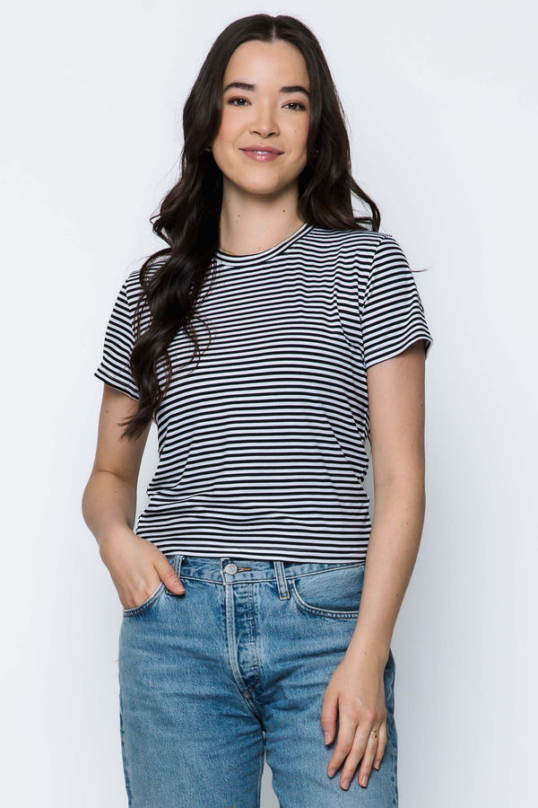 Woman wearing a striped t-shirt and jeans against a white background