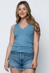 Woman wearing a blue sleeveless top and denim shorts on a white background