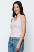 Woman wearing a striped tank top and jeans against a white background