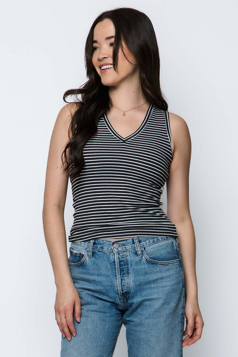 Woman wearing a striped tank top and jeans against a white background