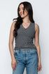 Woman wearing a striped tank top and jeans against a white background