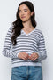 Woman wearing a striped sweater and jeans against a white background
