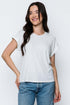 Woman wearing a white t-shirt and blue jeans against a plain background